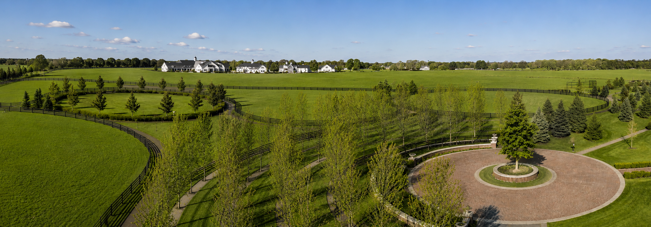 Gloss white Kuptz Steel Fence approaching a white estate barn with American flag at sunset